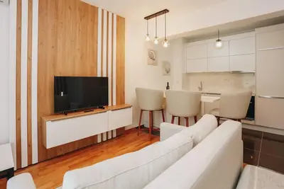 a living room with a white couch and a television at Status-M Apartments 135 in Becici