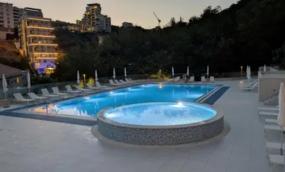 a large swimming pool with chairs and a table at Status-M Apartments 135 in Becici