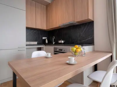a kitchen with a wooden table and white chairs at Horizon Two bedroom Apartment with sea view Jake in Becici