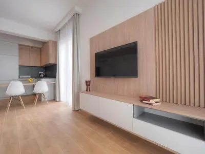 a living room with a television on a wall at Horizon Two bedroom Apartment with sea view Jake in Becici