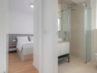 a bedroom with a bed and a glass shower at Horizon Two bedroom Apartment with sea view Jake in Becici