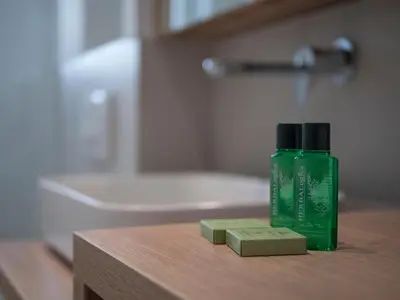 a green bottle of soap sitting on a table in a bathroom at Horizon Two bedroom Apartment with sea view Jake in Becici