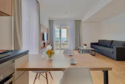 a kitchen and living room with a table and chairs at Horizon Two bedroom Apartment with sea view Jake in Becici