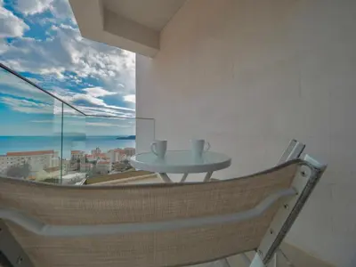 a table and chairs in a room with a window at Horizon Two bedroom Apartment with sea view Jake in Becici