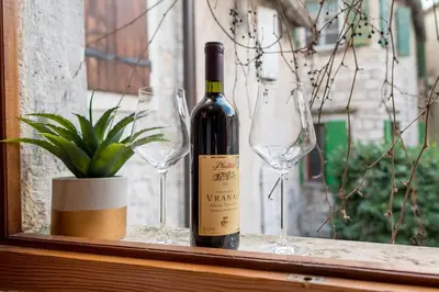 a bottle of wine and two wine glasses on a window at Little Bay Apartments in Kotor