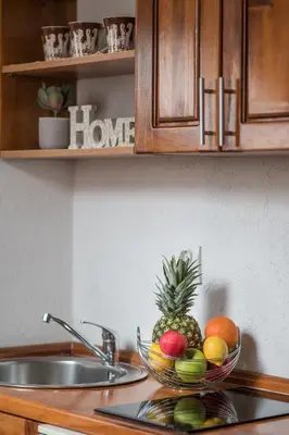 a bowl of fruit on a kitchen counter with a sink at Little Bay Apartments in Kotor
