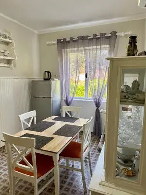 a kitchen with a table and chairs and a window at Red House Apartment in Kotor