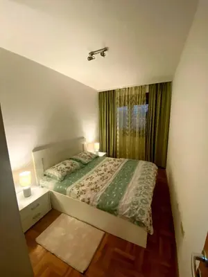 a small bedroom with a bed and a window at Comfort one bedroom apartment in Podgorica