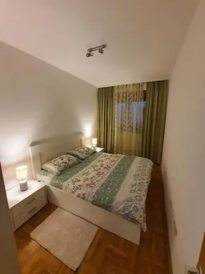 a small bedroom with a bed and a window at Comfort one bedroom apartment in Podgorica