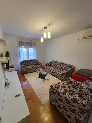 a living room with two couches and a table at Comfort one bedroom apartment in Podgorica