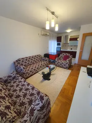 a living room with two couches and a table at Comfort one bedroom apartment in Podgorica