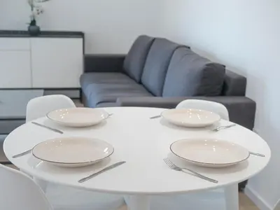 a white table with plates and chairs in a living room at Horizon-Two Bedroom Apartment Partial Sea View Charlene in Becici