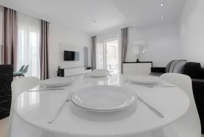 a white dining room table with white plates on it at Horizon-Two Bedroom Apartment Partial Sea View Charlene in Becici