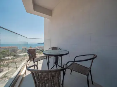 a table and chairs on a balcony with a view of the ocean at Horizon-Two Bedroom Apartment Partial Sea View Charlene in Becici