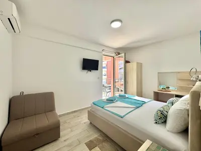 a bedroom with a bed and a chair and a window at Villa Ines in Budva