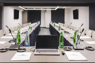 a long table with a laptop on it in a room at SIGNUM Hotel in Podgorica