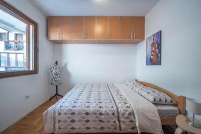 a bedroom with a bed and a window at Apartman J&I in Kotor