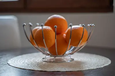 two oranges in a glass bowl on a table at Apartman J&I in Kotor