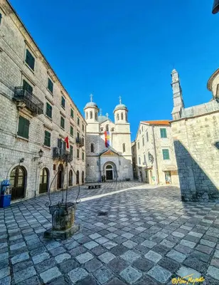 an old building with two towers in a courtyard at Apartman J&I in Kotor