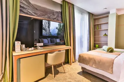 a bedroom with a bed and a desk with a computer at Carine Hotel Centar in Podgorica