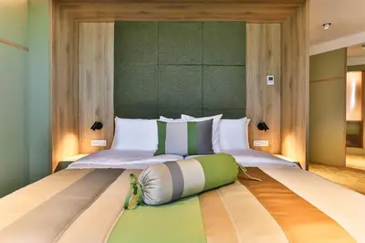 a bedroom with a large bed with a bag on it at Carine Hotel Centar in Podgorica