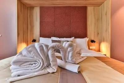 a bed with white towels on top of it at Carine Hotel Centar in Podgorica