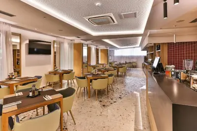 a restaurant with tables and chairs and a bar at Carine Hotel Centar in Podgorica