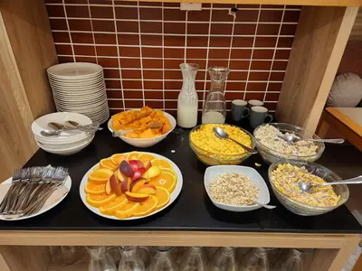 a table with plates of food and bowls of food at Carine Hotel Centar in Podgorica