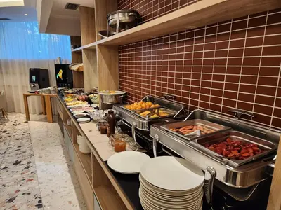 a buffet line in a restaurant with plates and food at Carine Hotel Centar in Podgorica