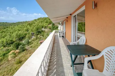 a balcony with a table and chairs on a house at Apartman -PANORAMA LUX in Sutomore