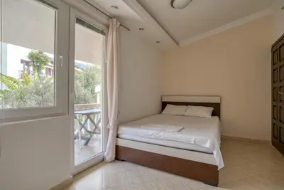 a bedroom with a bed and a large window at Apartman -PANORAMA LUX in Sutomore