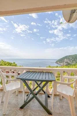 a table and chairs on a balcony with a view of the ocean at Apartman -PANORAMA LUX in Sutomore