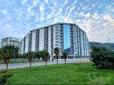 a large building with palm trees in front of it at M & A Apartment Bar A 29 in Bar