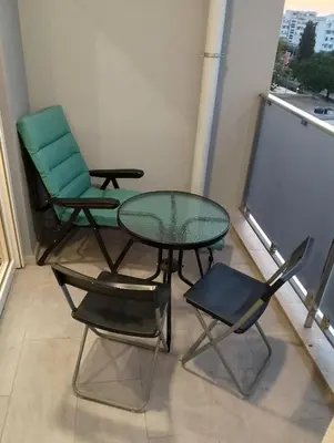 two chairs and a glass table and chairs on a balcony at M & A Apartment Bar A 29 in Bar
