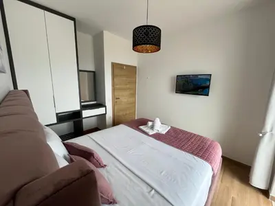 a bedroom with a bed and a couch at Art's Apartment mit Pool Ulcinj Pinjes in Ulcinj
