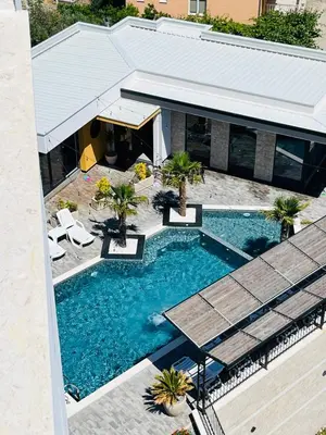 an overhead view of a swimming pool with chairs and a building at Art's Apartment mit Pool Ulcinj Pinjes in Ulcinj