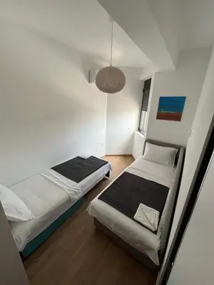 a bedroom with two beds and a pendant light at Art's Apartment mit Pool Ulcinj Pinjes in Ulcinj