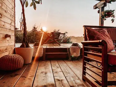 a sunbeam shines on a wooden deck with a table at Zen House for 2 in Ulcinj