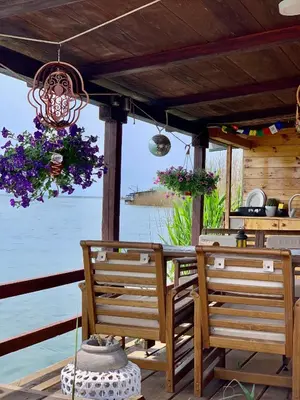 a porch with two chairs and a table with flowers at Zen House for 2 in Ulcinj