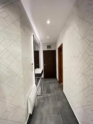 a hallway of a bathroom with a sink and a mirror at Varja 3 Apartment in Pržno