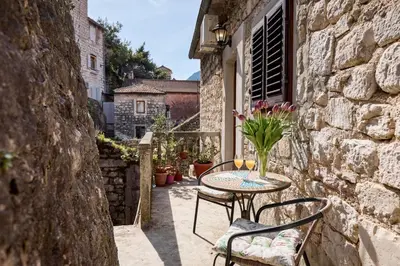 a table with a vase of flowers on a patio at Old Town Terrace Vibe in Kotor
