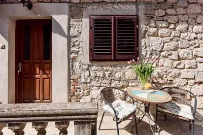 a patio with a table and chairs next to a building at Old Town Terrace Vibe in Kotor
