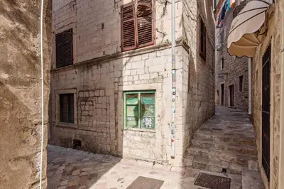 an alley in an old stone building with a window at Old Town Terrace Vibe in Kotor