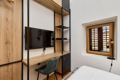 a room with a bed and a desk and a television at Old Town Terrace Vibe in Kotor
