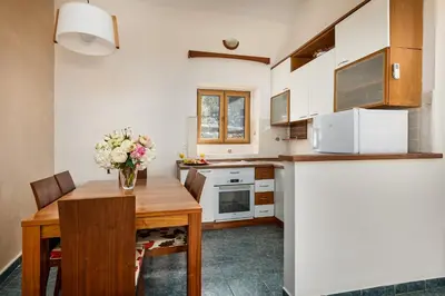 a kitchen with a wooden table with a vase of flowers at Old Town Terrace Vibe in Kotor