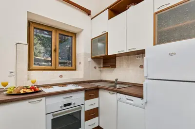 a white kitchen with a sink and a refrigerator at Old Town Terrace Vibe in Kotor