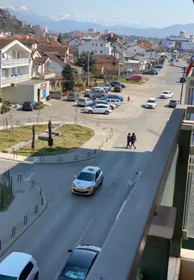 a car driving down a city street with parked cars at Apartman Bojanic in Podgorica