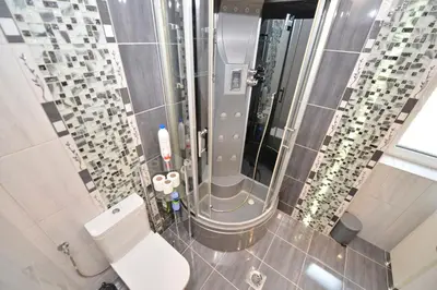 a bathroom with a toilet and a lot of glass tiles at Sofija Apartment in Kotor