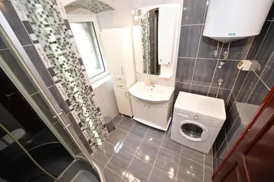 a small bathroom with a sink and a washing machine at Sofija Apartment in Kotor