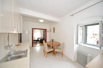 a kitchen and dining room with a table and chairs at Sofija Apartment in Kotor